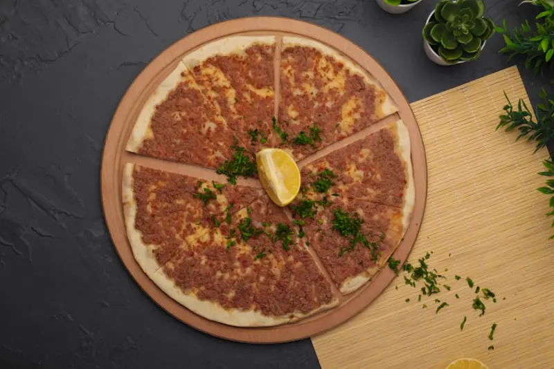 Lahmacun auf einem Holzbrett mit Petersilie und Zitrone