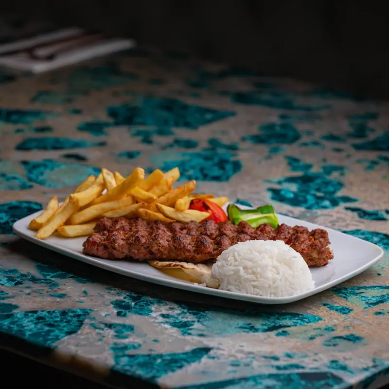 Kebabteller mit Reis, Pommes und gegrilltem Gemüse