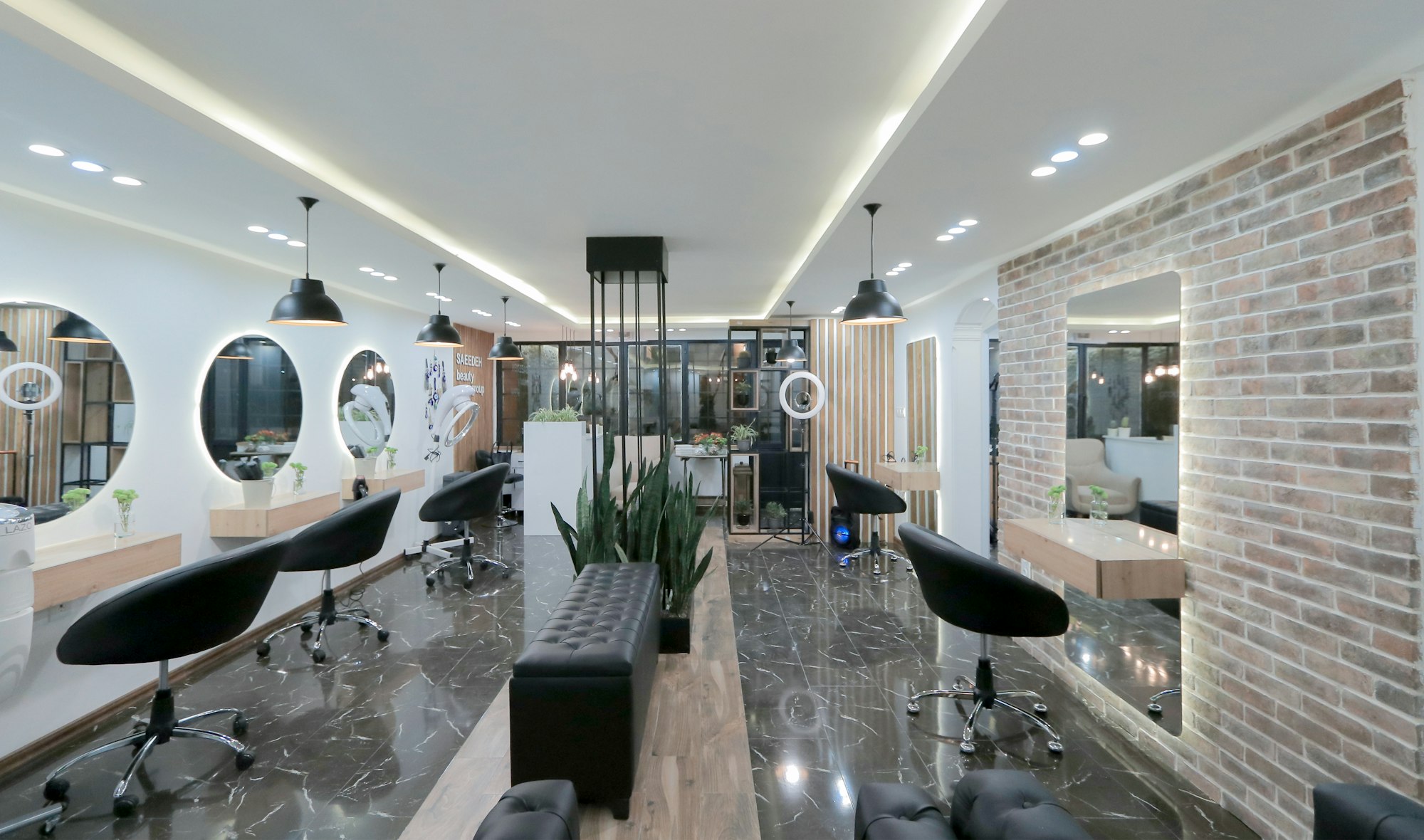 Moderner Friseursalon mit schwarzen Stühlen, runden Spiegeln und Backsteinwand